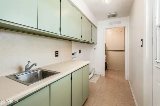 a kitchen with a sink a refrigerator and cabinets
