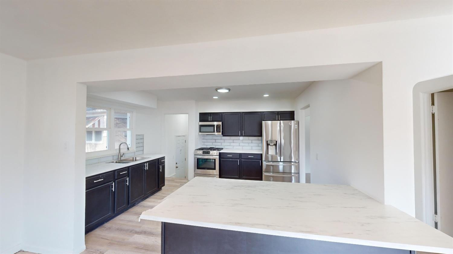608 East Ridge Road Gary, IN 46409 - Photo 5 of 27 a large kitchen with kitchen island a sink stainless steel appliances and cabinets