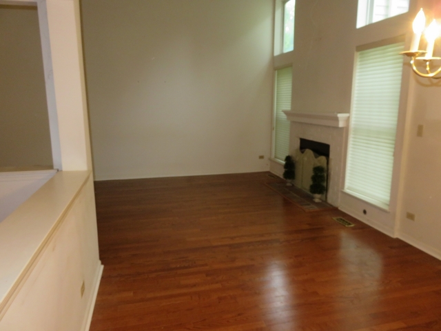 2116 Peach Tree Lane, Unit 4243 Algonquin, IL 60102 - Photo 12 of 25 an empty room with wooden floor and a window