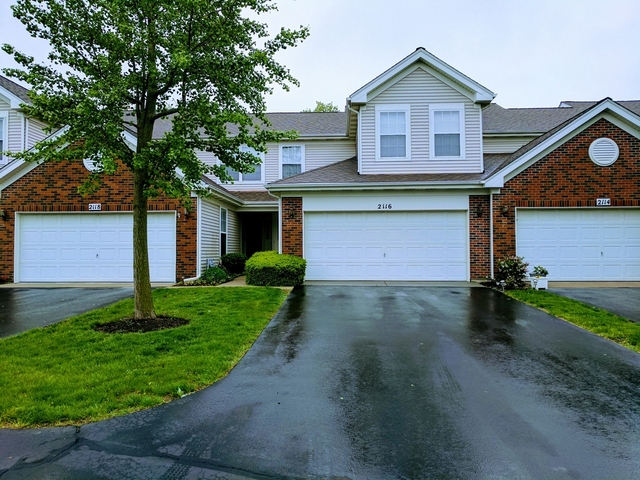 2116 Peach Tree Lane, Unit 4243 Algonquin, IL 60102 - Photo 2 of 25 a front view of a house with a yard and garage