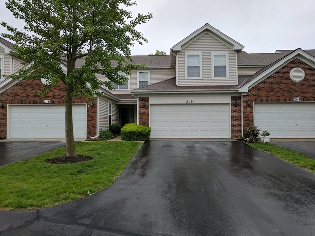 2116 Peach Tree Lane, Unit 4243 Algonquin, IL 60102 - Photo 24 of 25 a front view of a house with a yard and garage