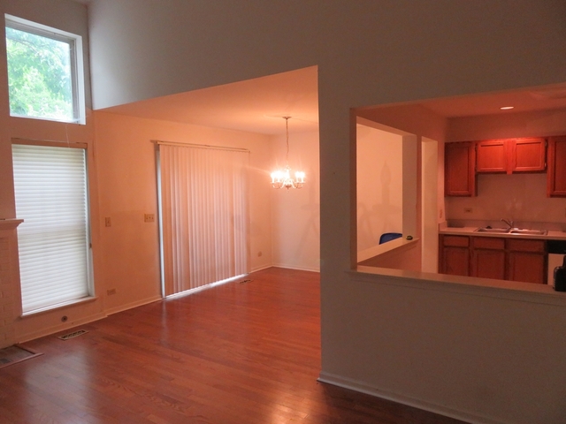 2116 Peach Tree Lane, Unit 4243 Algonquin, IL 60102 - Photo 6 of 25 an empty room with wooden floor and windows