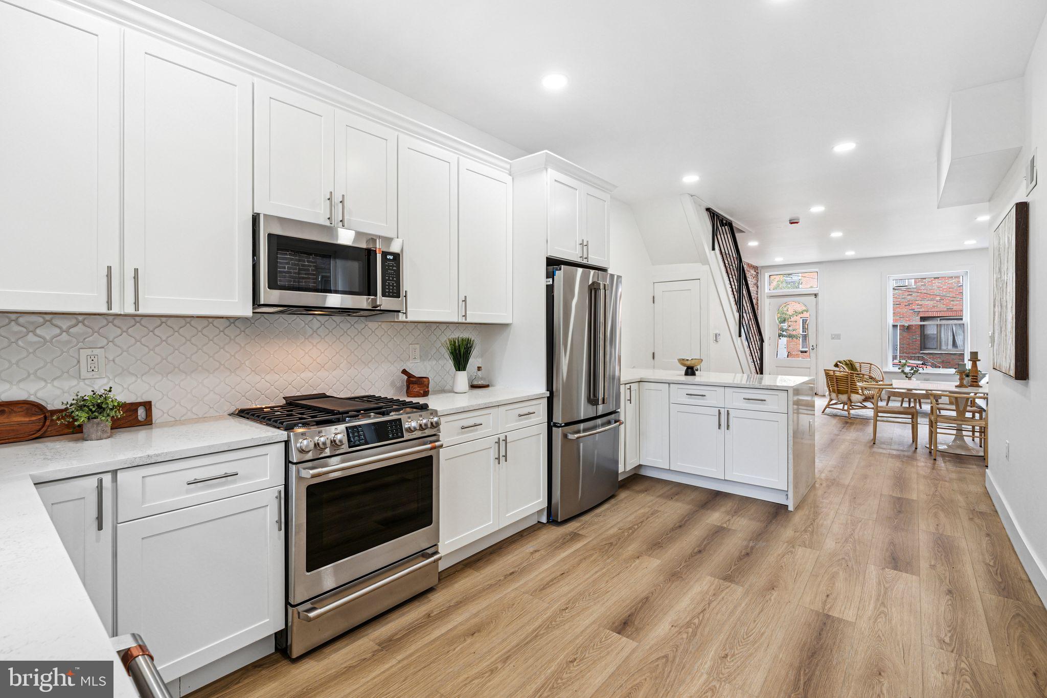 908 Reed Street Philadelphia, PA 19147 - Photo 9 of 33 a kitchen with stainless steel appliances a stove a sink a refrigerator white cabinets and wooden floor