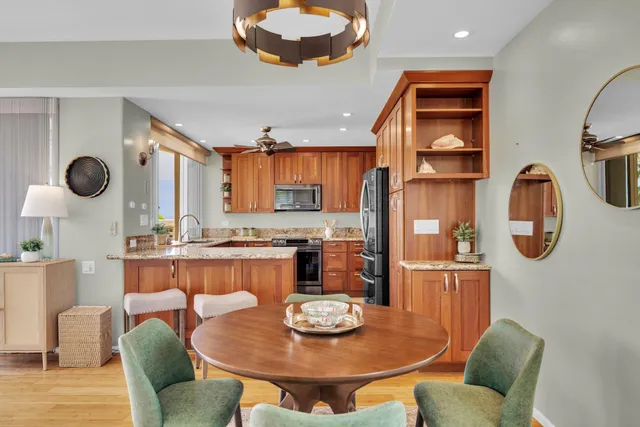 a kitchen with stainless steel appliances kitchen island granite countertop a table and chairs