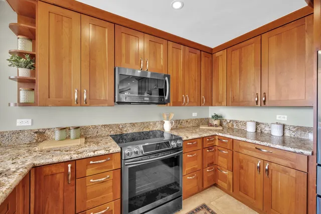 a kitchen with stainless steel appliances granite countertop a sink stove and microwave