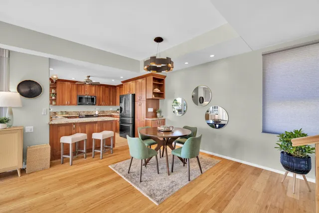 a dining room with wooden floor a glass table and chairs