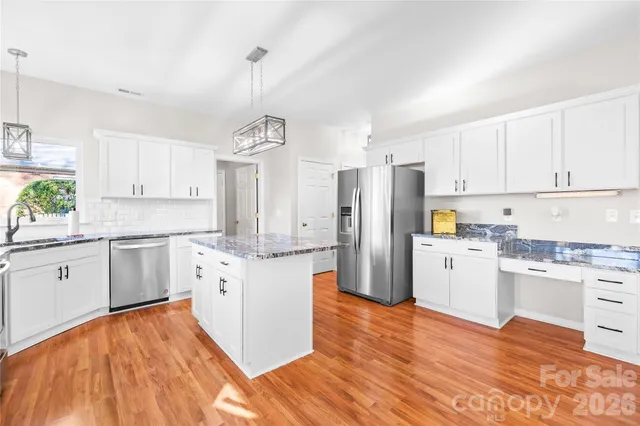 a kitchen with stainless steel appliances granite countertop a sink stove and refrigerator
