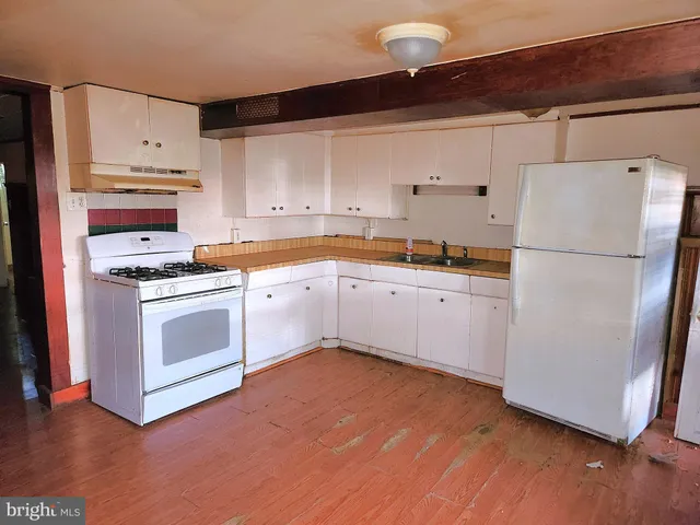a kitchen with cabinets a white stainless steel appliances and wooden floor