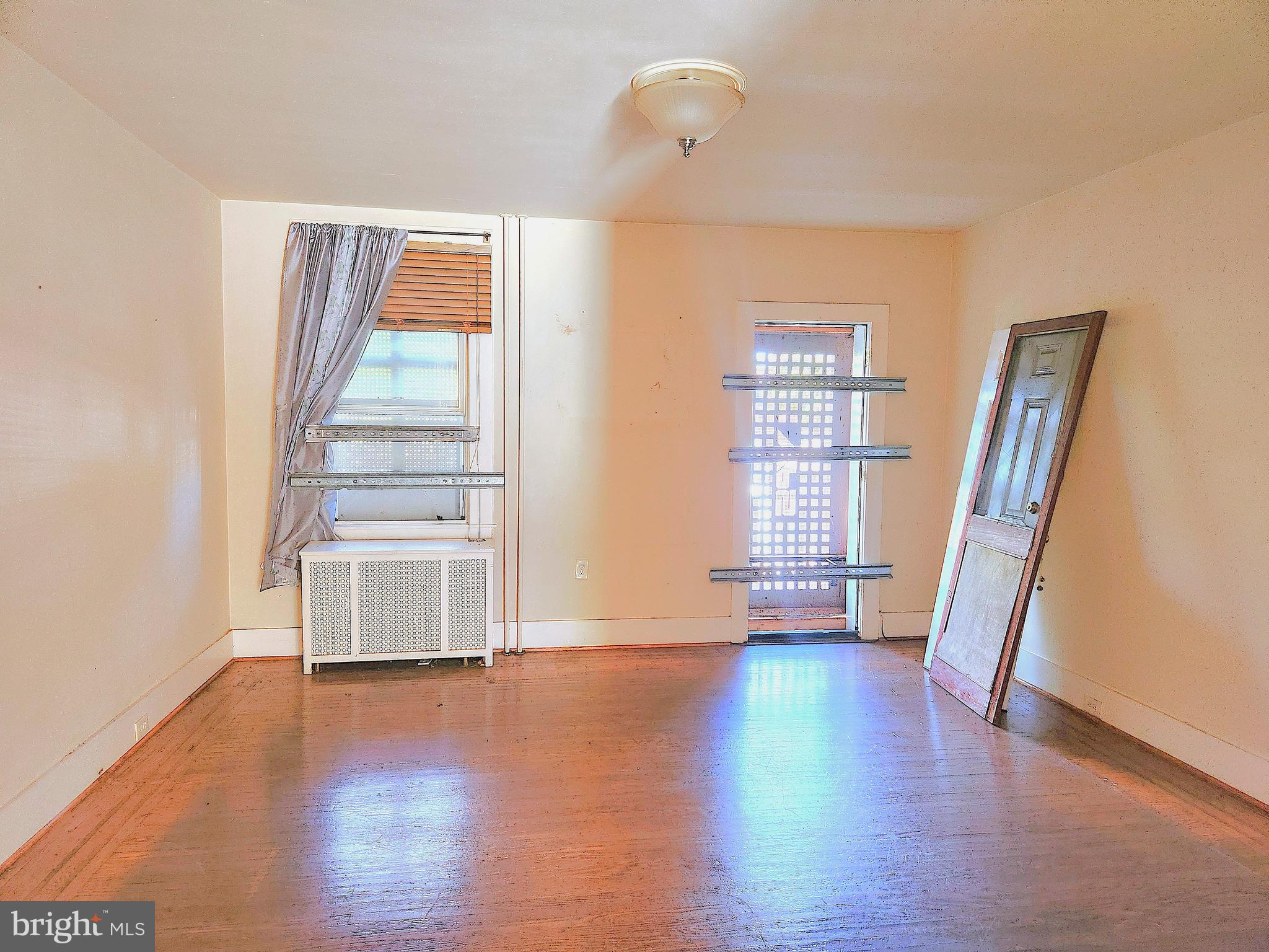 3336 Chesterfield Avenue Baltimore, MD 21213 - Photo 4 of 16 an empty room with wooden floor and windows