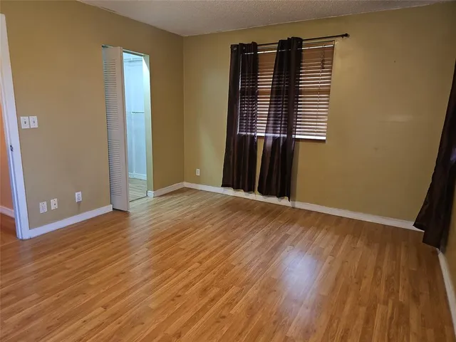a view of a room with wooden floor and a window