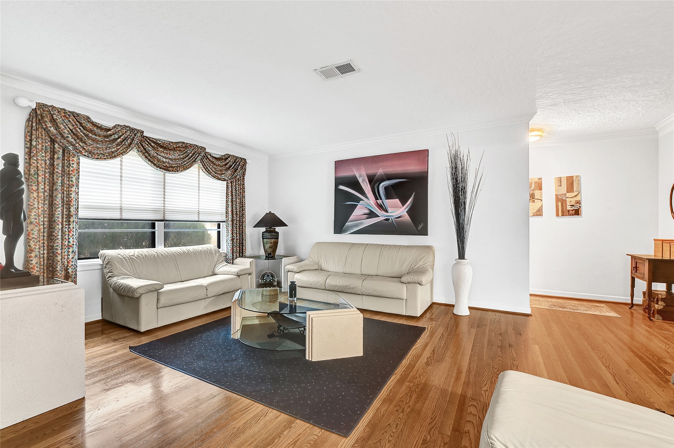 4831 Knickerbocker Street Houston, TX 77035 - Photo 5 of 50 Open living room with elegant drapery, hardwood floors, and generous seating space.