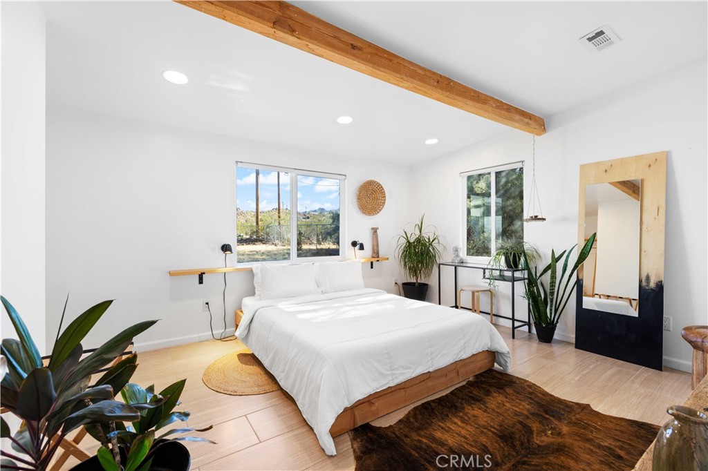61879 Valley View Circle Joshua Tree, CA 92252 - Photo 16 of 63 a bedroom with a large bed and a potted plant