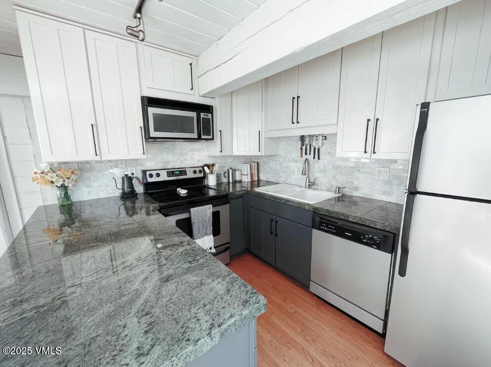 2958 South Frontage Road West, Unit B5 Vail, CO 81657 - Photo 4 of 13 a kitchen with stainless steel appliances granite countertop a sink stove and refrigerator