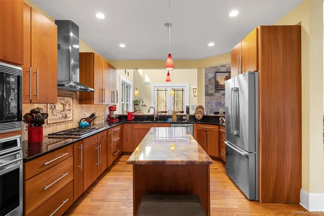a view of a kitchen with stainless steel appliances a refrigerator and a stove