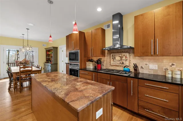 a kitchen with stainless steel appliances granite countertop wooden cabinets a stove and a sink