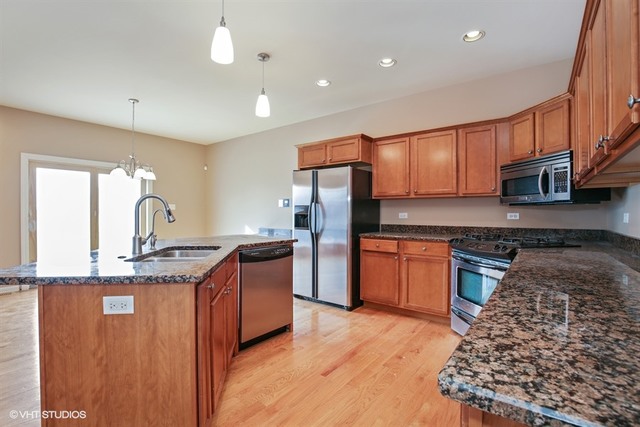 2309 Dean Street Sycamore, IL 60178 - Photo 5 of 25 a kitchen with stainless steel appliances granite countertop a sink stove and refrigerator
