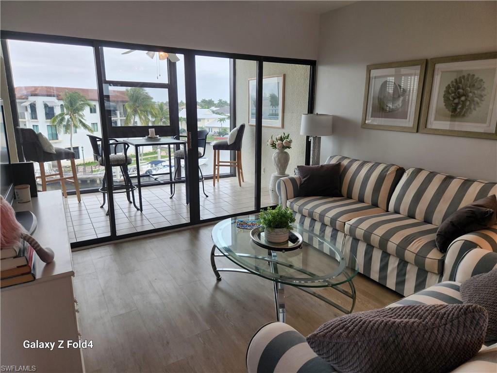 805 River Point Drive, Unit C307 Naples, FL 34102 - Photo 13 of 31 a living room with furniture and a floor to ceiling window