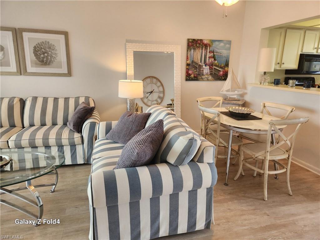 805 River Point Drive, Unit C307 Naples, FL 34102 - Photo 6 of 31 a living room with furniture a flat screen tv and a table