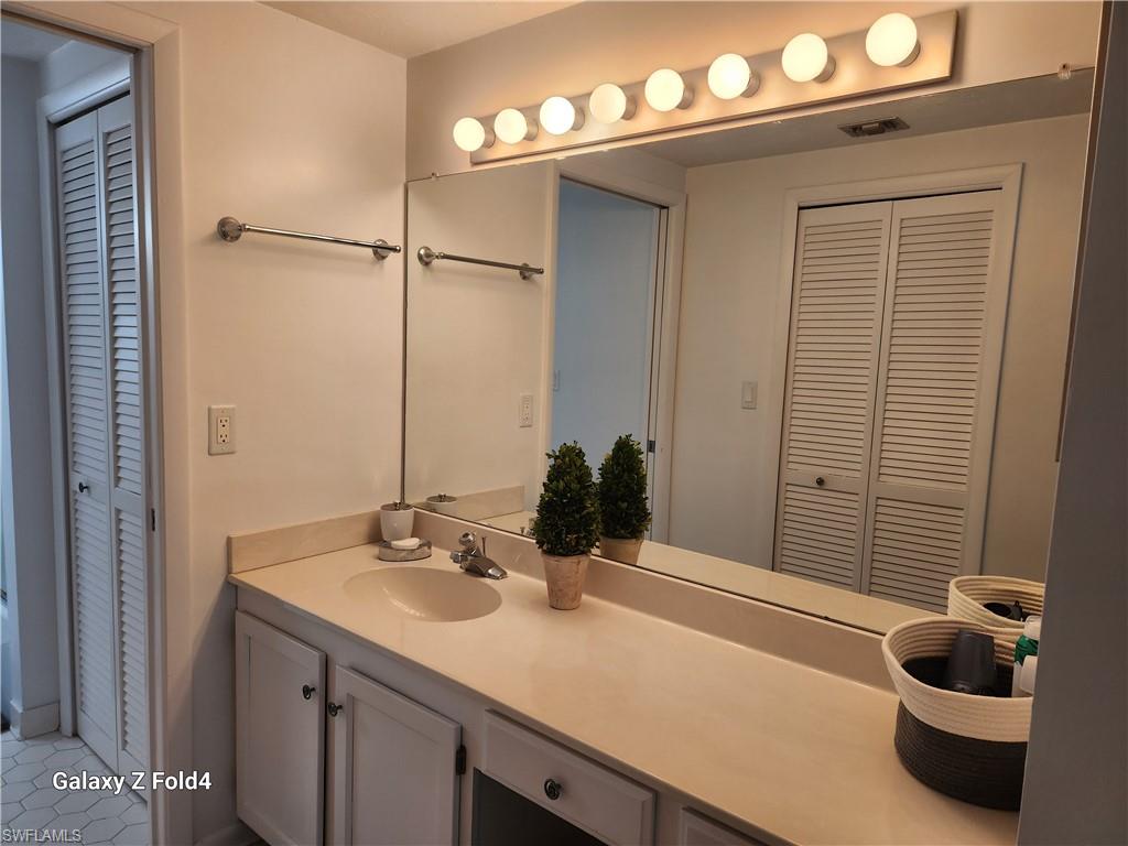 805 River Point Drive, Unit C307 Naples, FL 34102 - Photo 10 of 31 a bathroom with a sink and a mirror