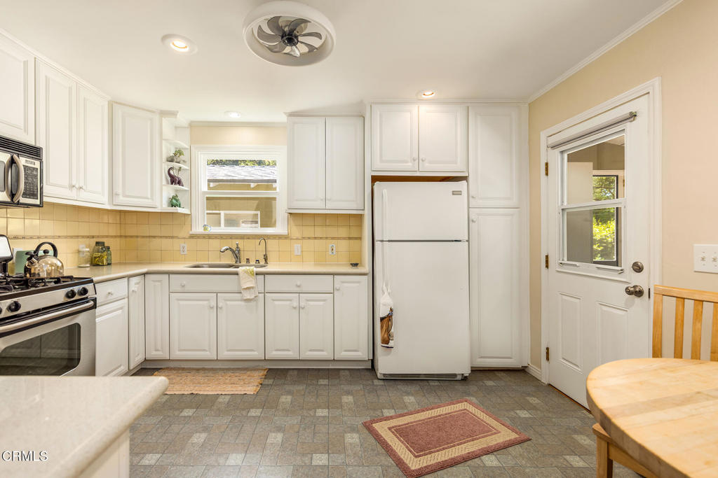 840 Fairview Road Ojai, CA 93023 - Photo 6 of 34 a kitchen with a refrigerator a stove top oven and white cabinets