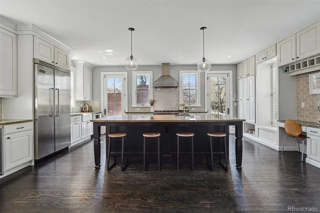 a kitchen with stainless steel appliances granite countertop a sink stove and wooden floor
