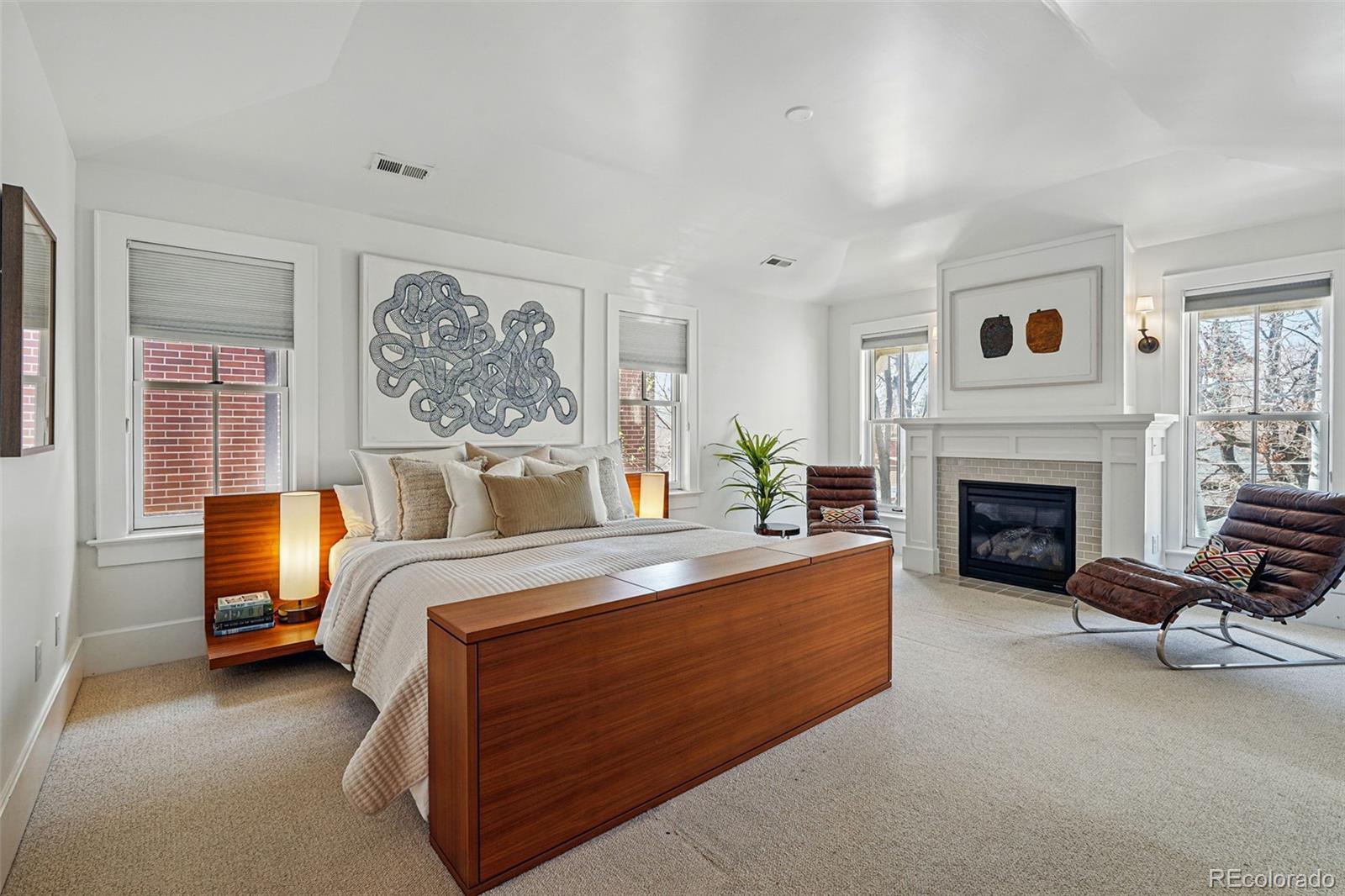 201 South Lafayette Street Denver, CO 80209 - Photo 20 of 48 a spacious bedroom with a bed and a fireplace