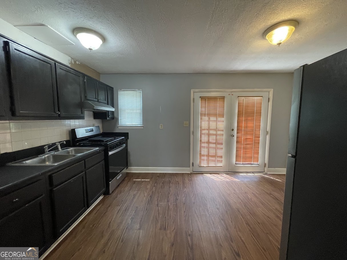 1625 Conley Road, Unit 254 Conley, GA 30288 - Photo 5 of 10 a kitchen with granite countertop wooden floors and black stainless steel appliances