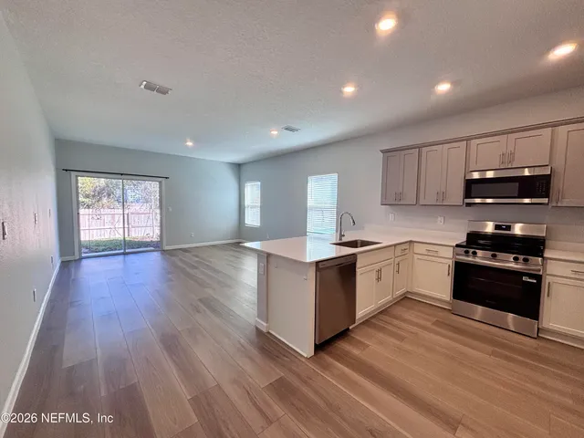 a kitchen with granite countertop a refrigerator stove top oven and sink