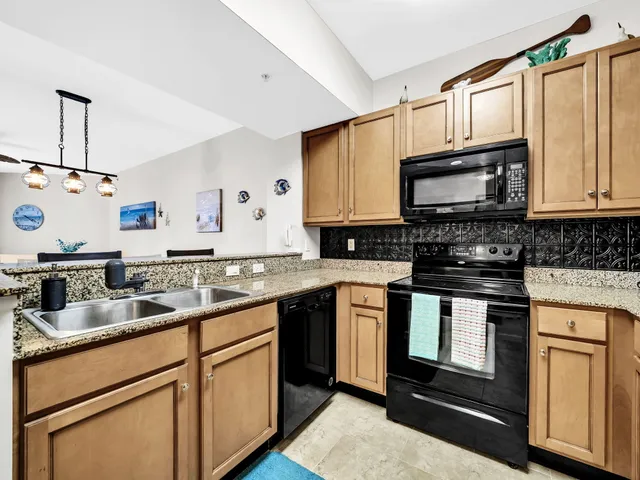 a kitchen with granite countertop cabinets stainless steel appliances and a sink