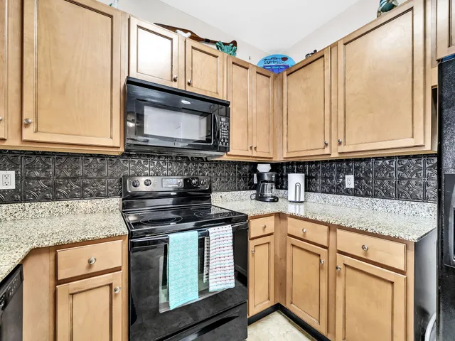 a kitchen with granite countertop a sink a stove and cabinets