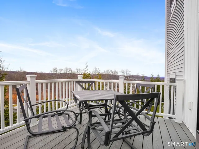 a view of a balcony with wooden chairs