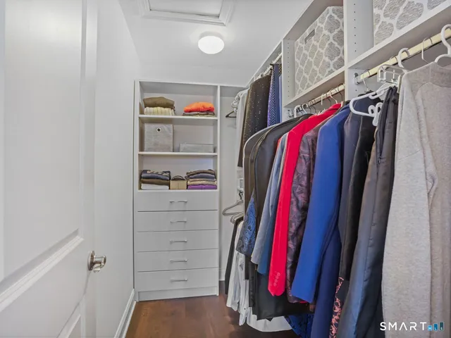 a view of walk in closet with clothes and shoes