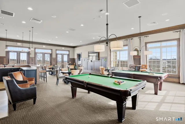 a room with pool table and windows