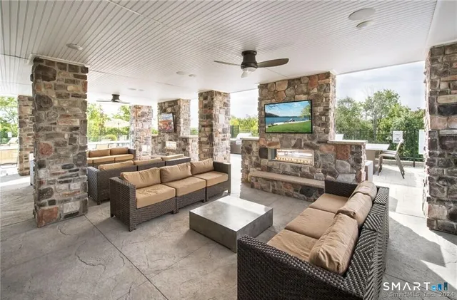 a living room with furniture a flat screen tv and a large window
