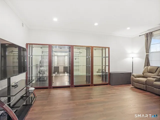 a living room with furniture a flat screen tv and a floor to ceiling window