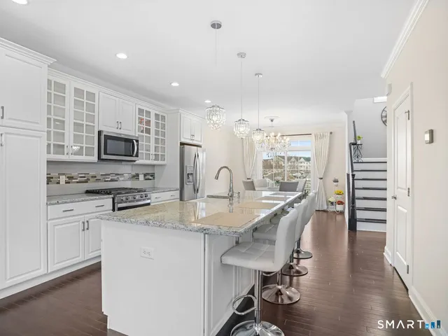a view of a kitchen with kitchen island a sink stainless steel appliances and cabinets