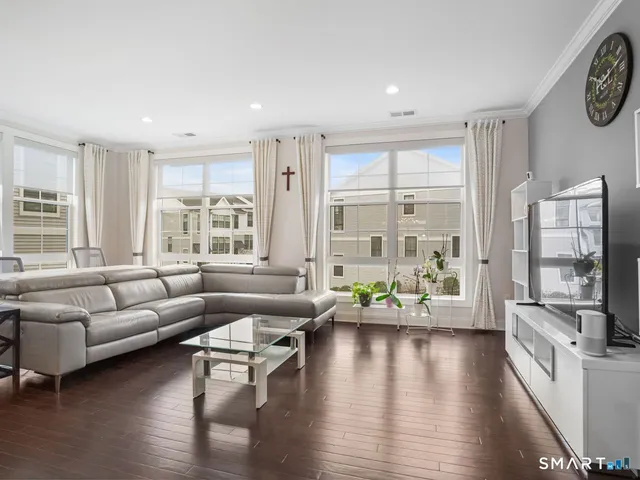 a living room with furniture flat screen tv and a large window