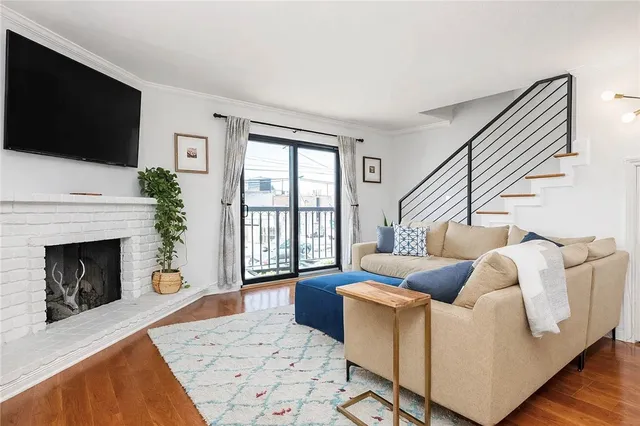 a living room with furniture a flat screen tv and a fireplace
