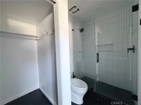 a bathroom with a granite countertop toilet a sink and shower