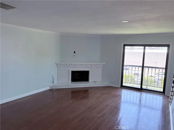 an empty room with wooden floor and fireplace