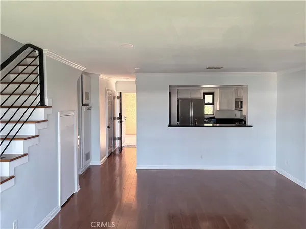 a view of a hallway with wooden floor and a living room