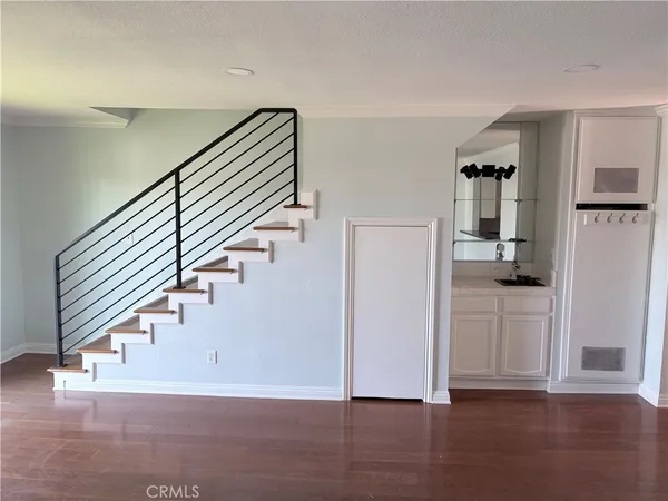 a view of hallway with stairs and wooden floor