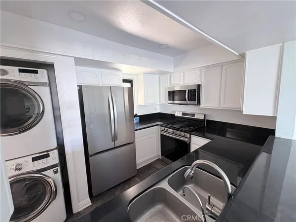 a kitchen with a refrigerator a washer and dryer