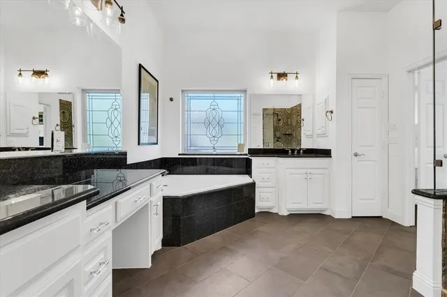 a kitchen with granite countertop a sink and white cabinets