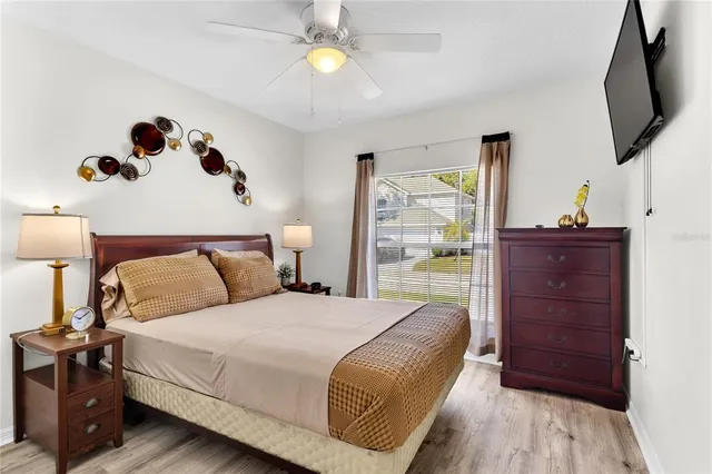 a bedroom with a bed and a flat tv screen on dresser
