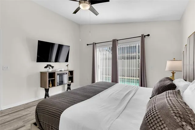 a bedroom with a bed and a flat tv screen on a dresser