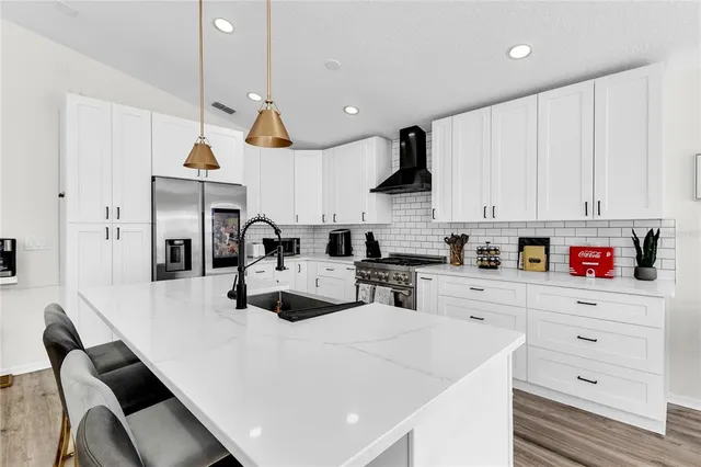a kitchen with white cabinets and stainless steel appliances