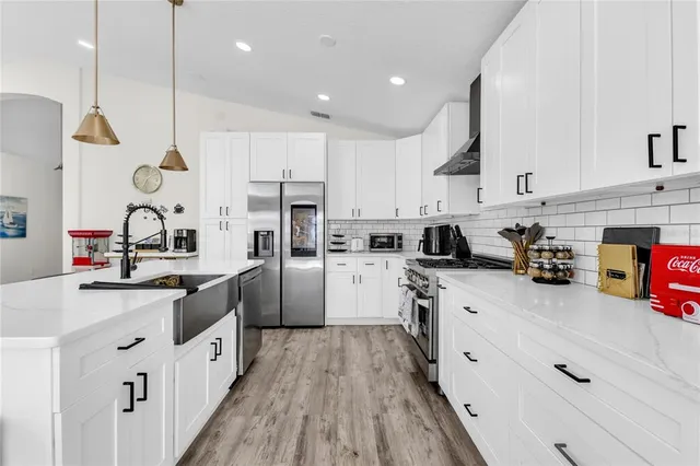 a kitchen with granite countertop a sink a counter space appliances and cabinets