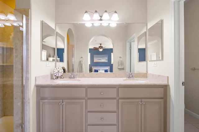 a bathroom with a granite countertop sink a large mirror and a shower
