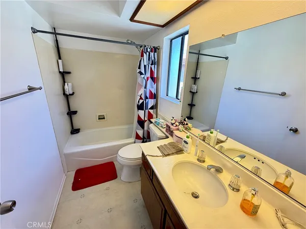 a bathroom with a tub sink mirror vanity and toilet